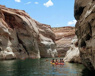 people canoeing through a slot canyon