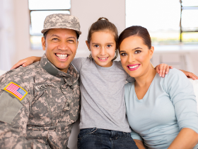 Family sitting on couch. Male adult in uniform