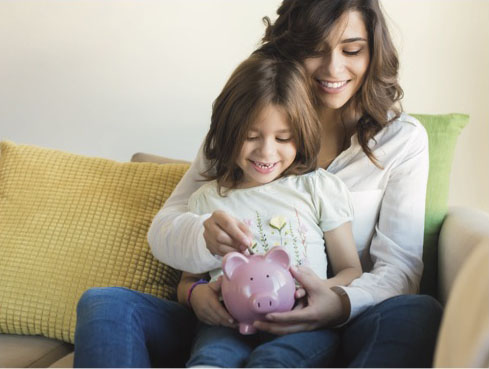 Mom with child putting money into a piggy bank
