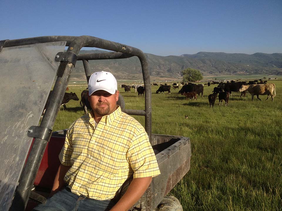 Agrability client Tyler Hunter sitting in a side-by-side in a field of cattle