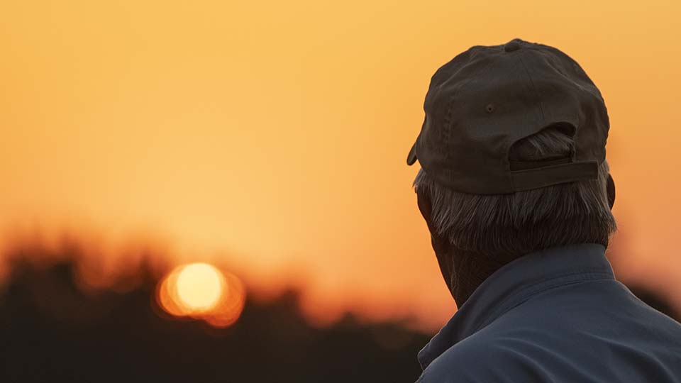 Farmer looking at sunset
