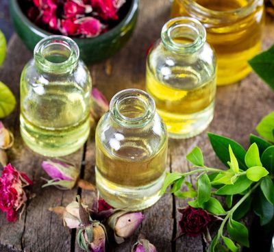3 small jars of sugar syrups with flowers on the table near them. 