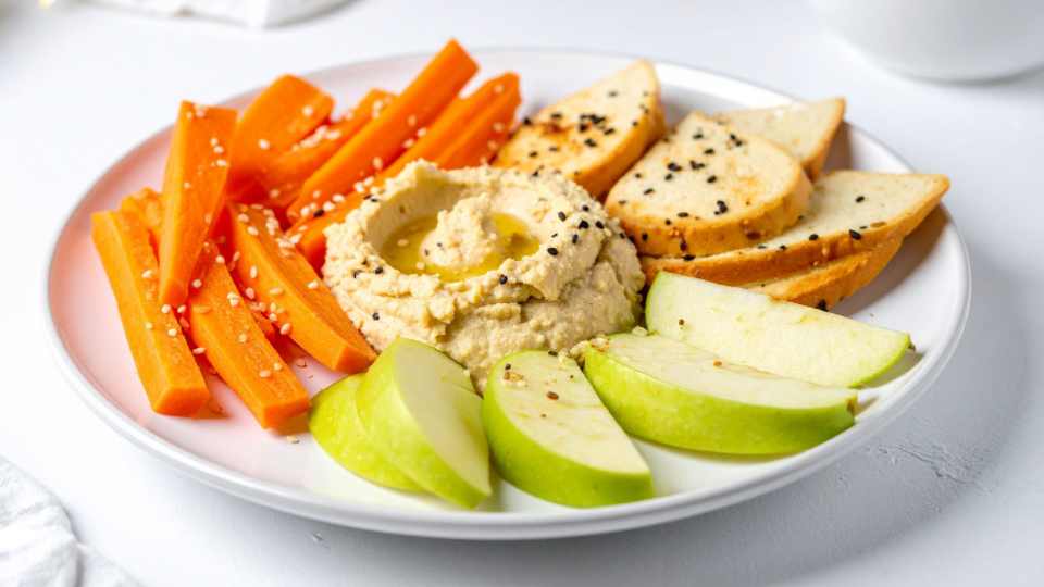 Vegetables, crackers, and apple slices with hummus