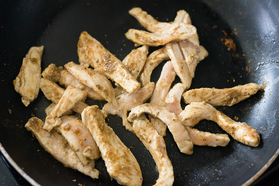 chicken cooking in skillet for chicken gyro plate
