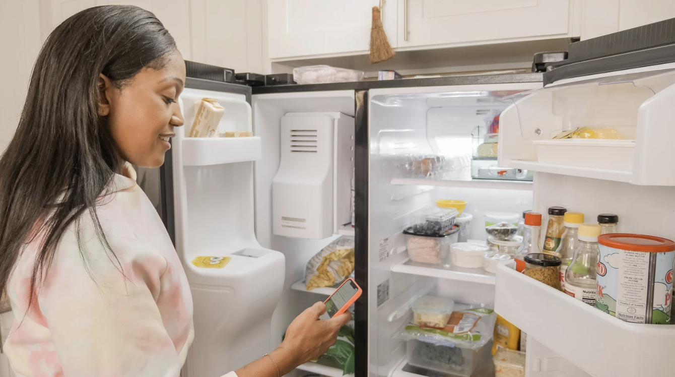 woman looking in fridge while menu planning 
