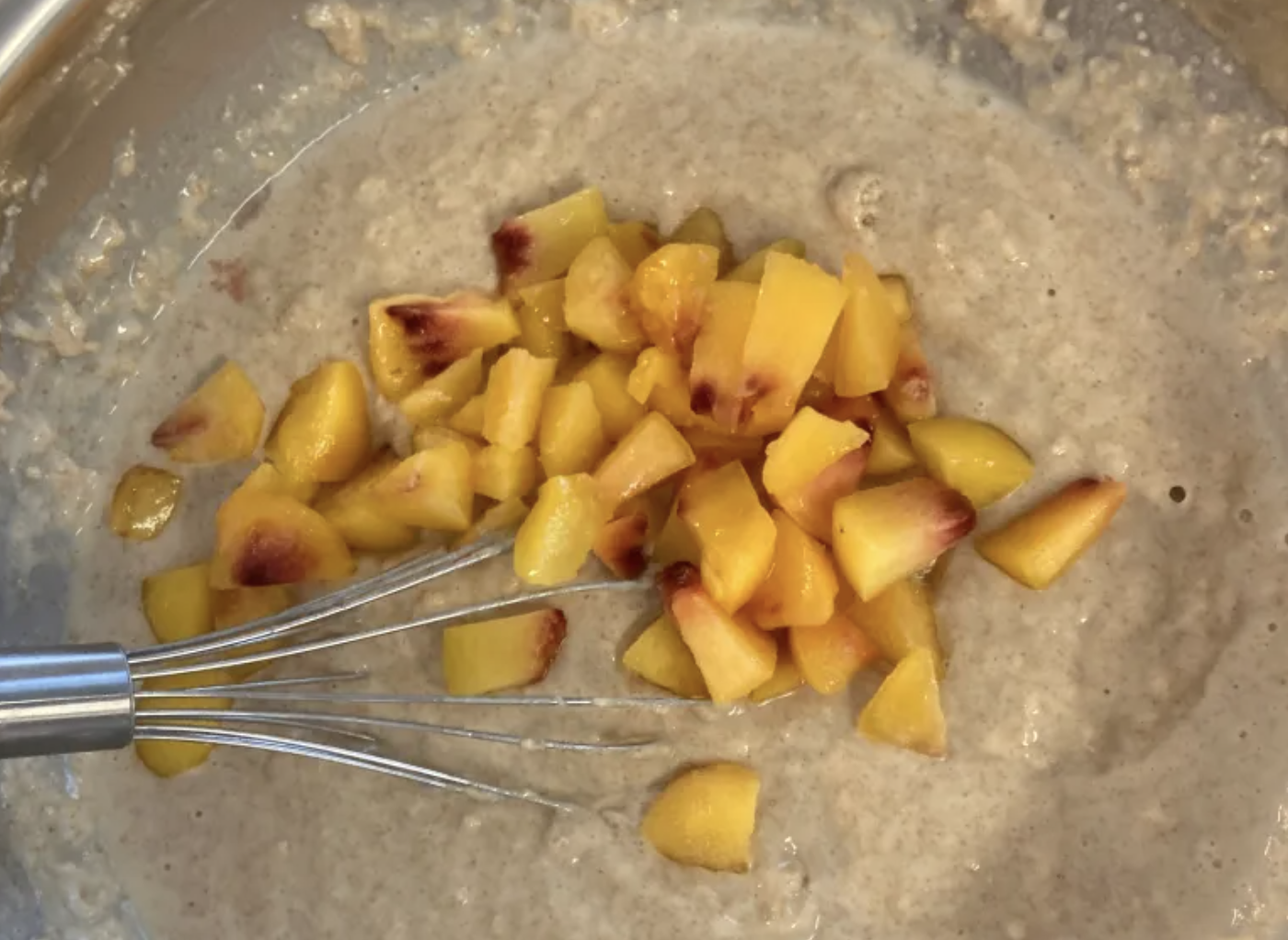 peaches being mixed into pancake batter 