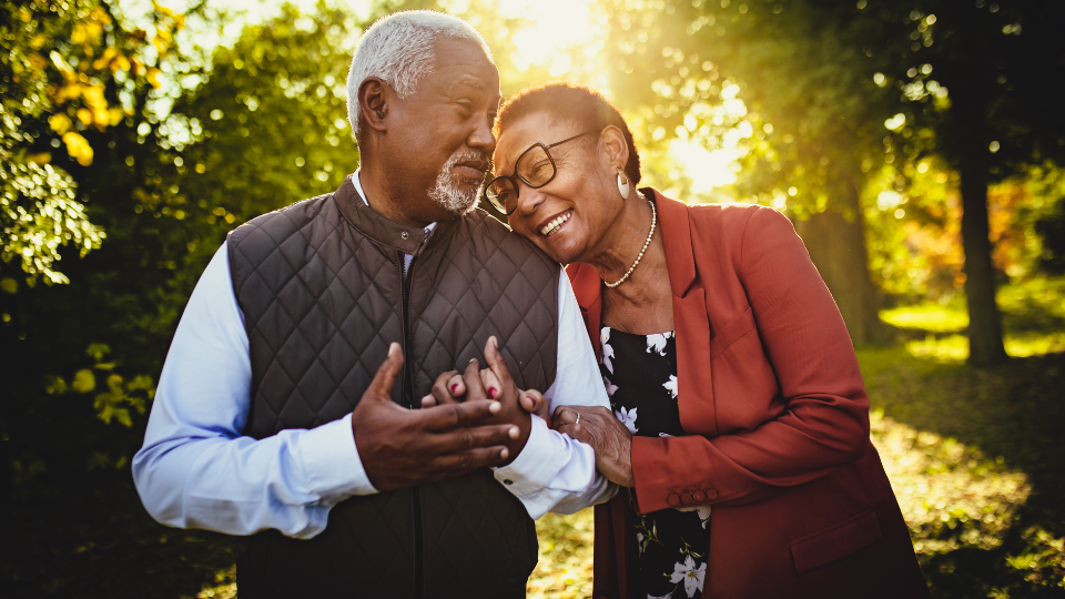 A man and women in their mid-years hold hands.