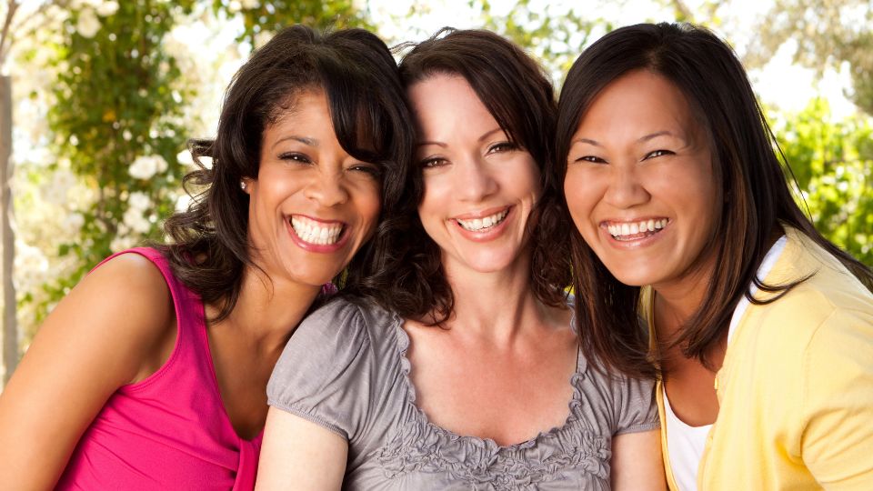 3 middle aged women smiling.