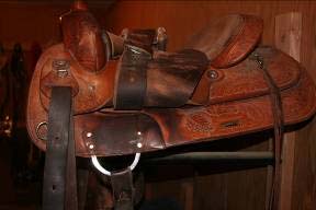 Single-rigged saddle with front girth only. The front girth is sewn in and riveted to skirt of saddle.
