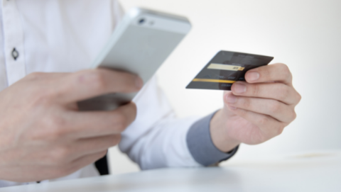 man holding phone and credit card