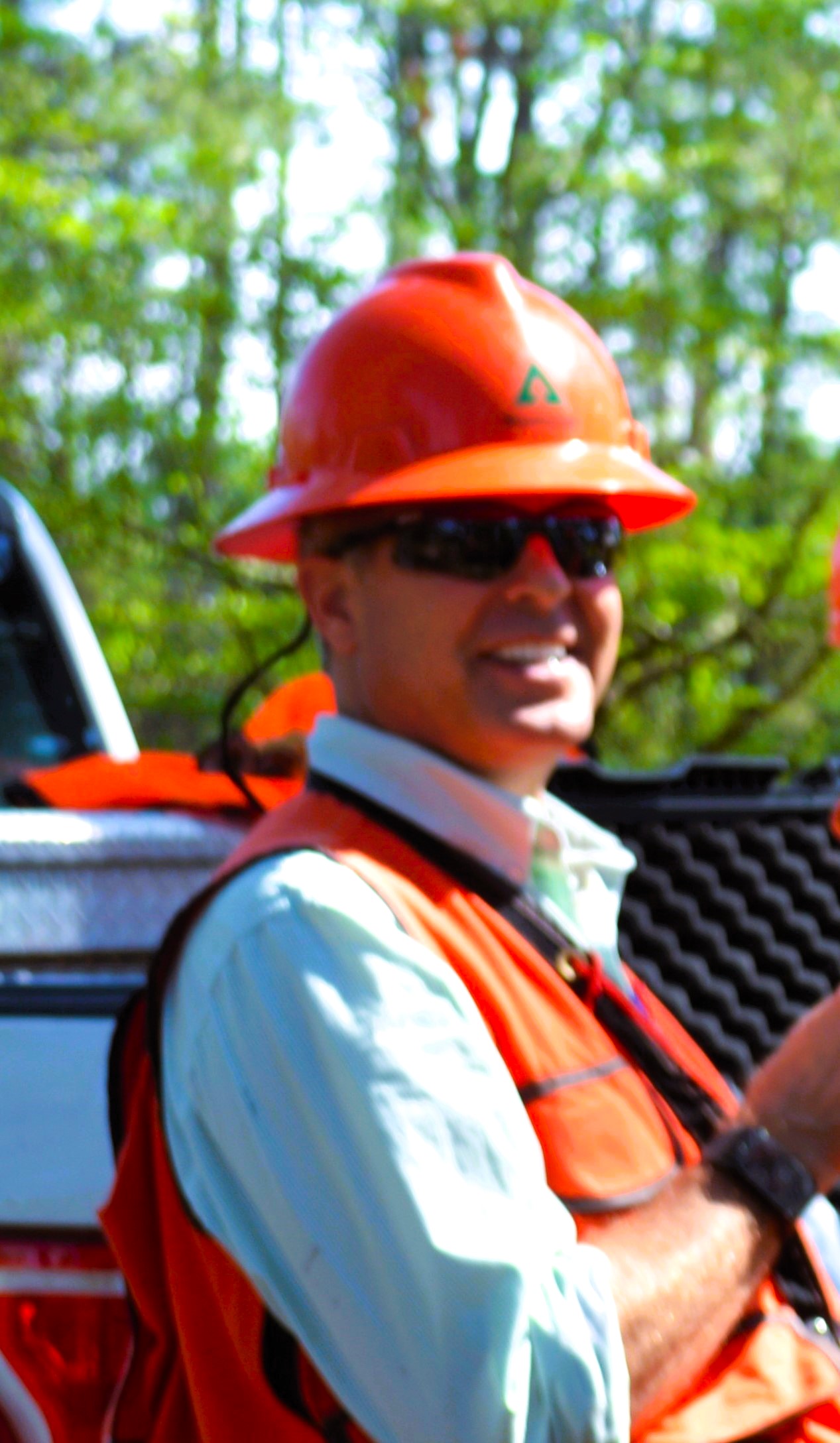 A man wearing an orange vest and a hard hat