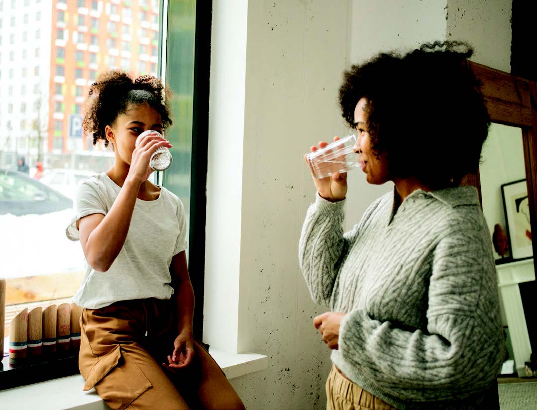 A mother and daughter drinking water together