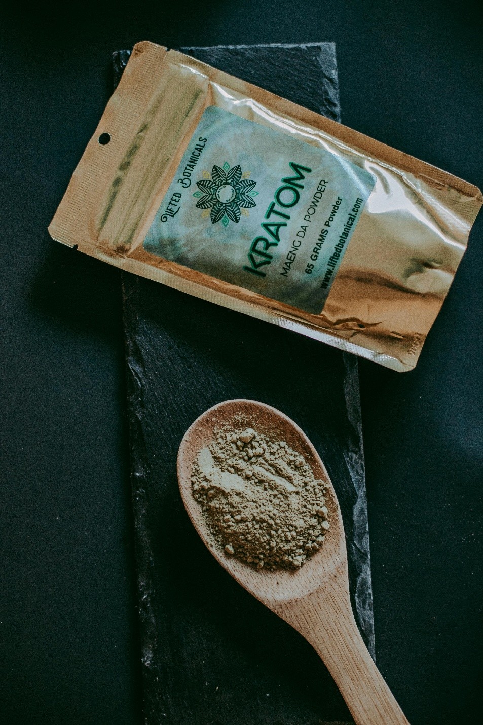 A bag of Kratom as well as a big wooden spoon with kratom powder in it.