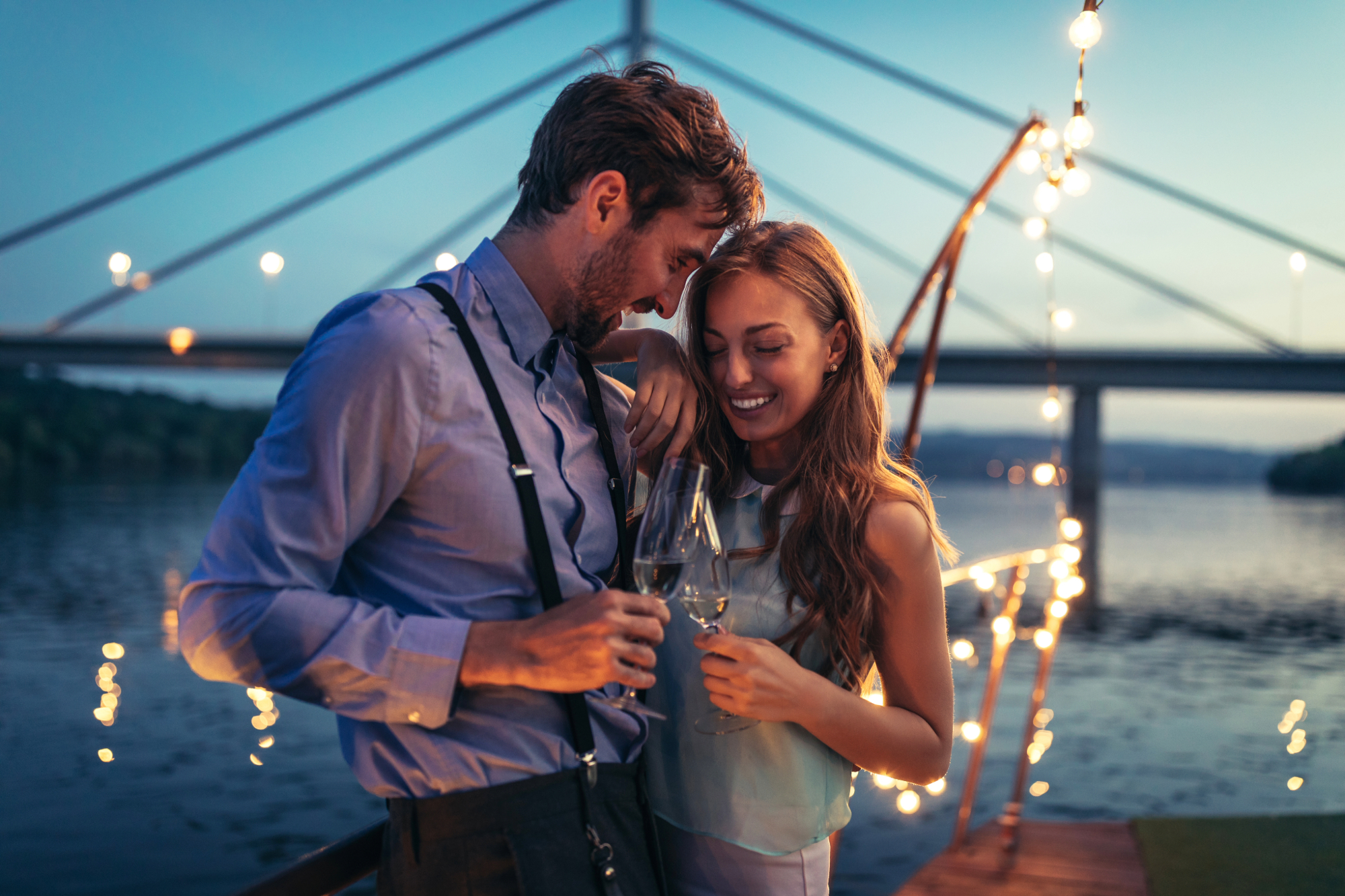 man and woman hugging each other while laughing during the night on a boat