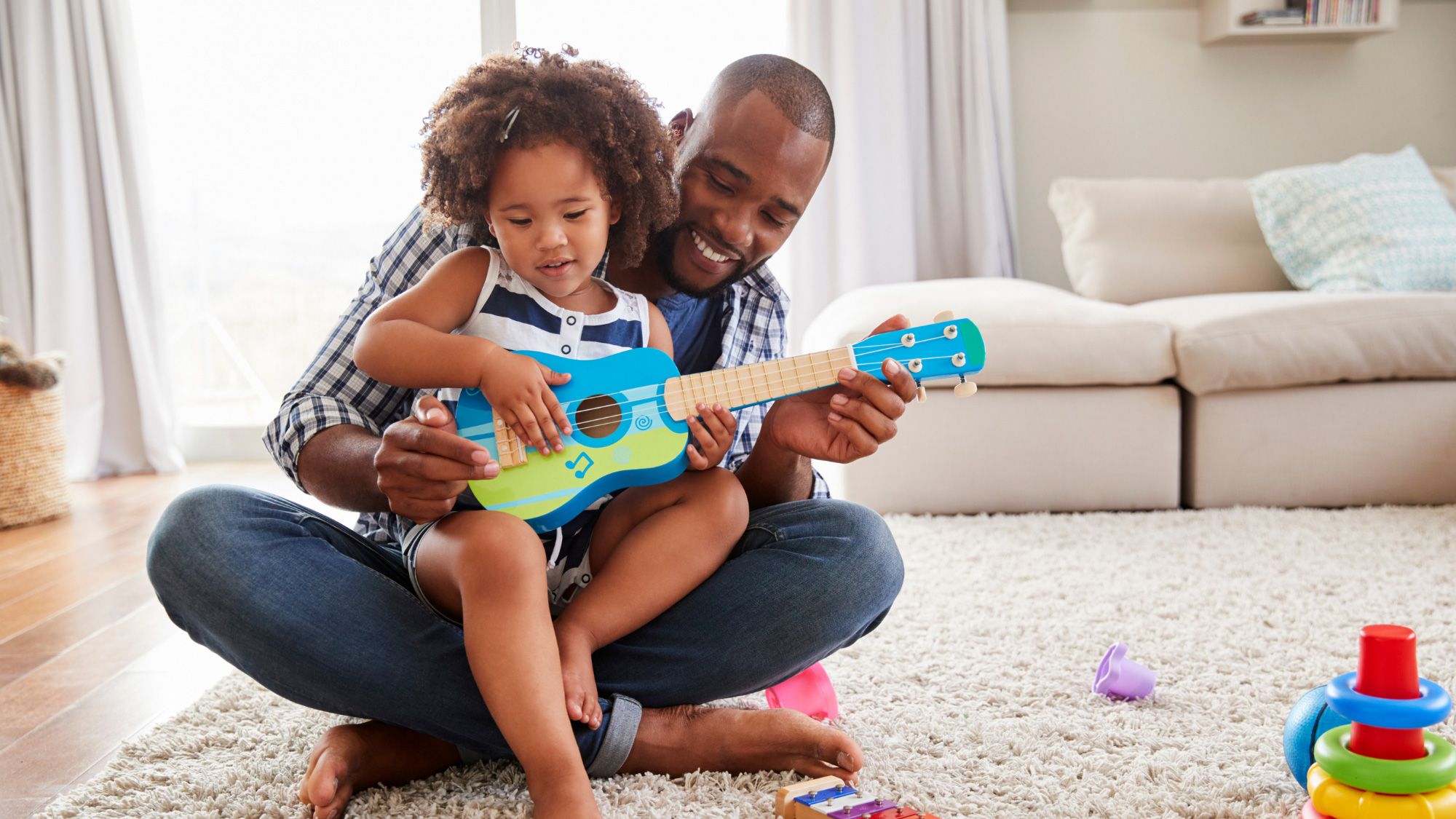 A father playing a ukelele with his child