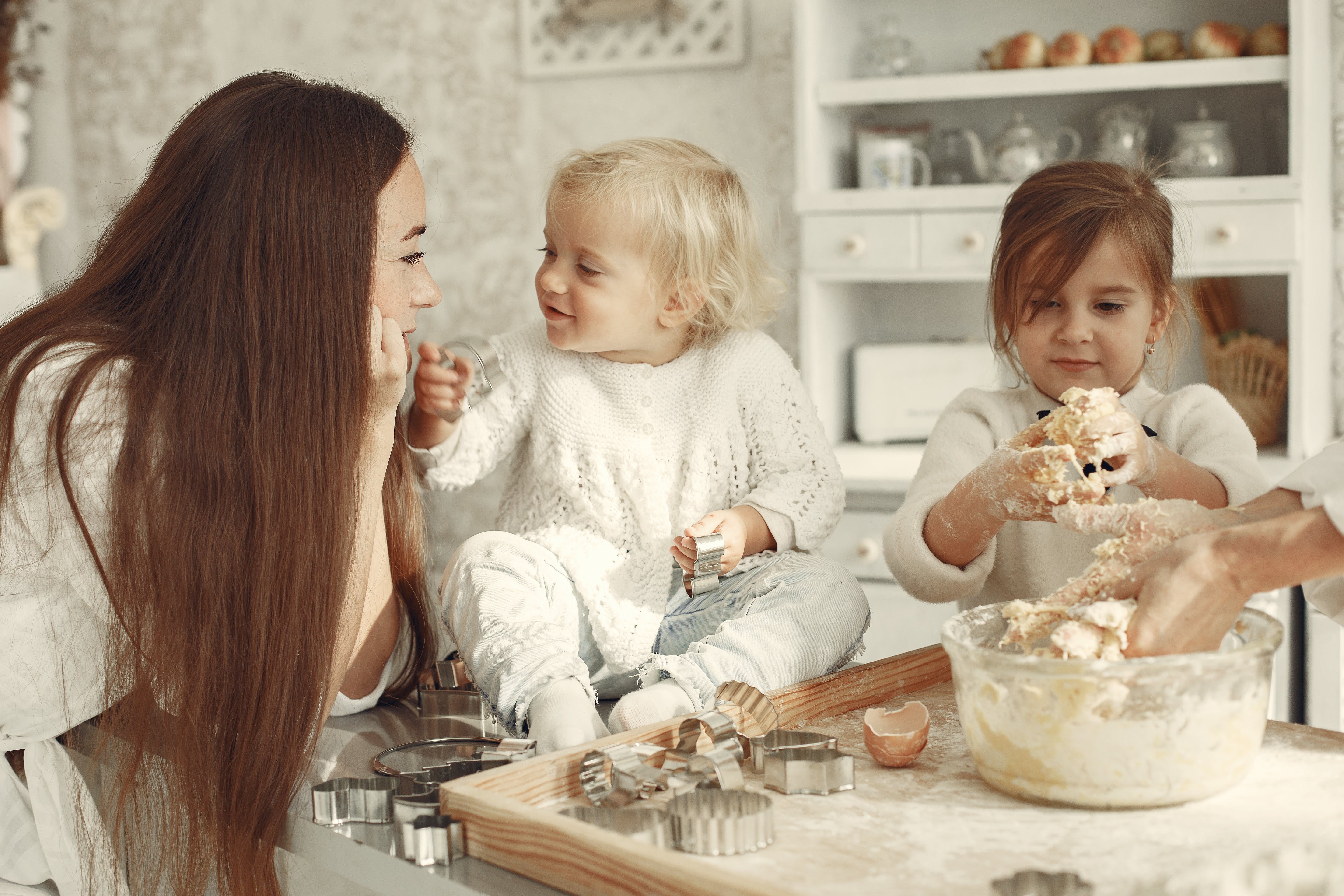 mother making cookies with two kids
