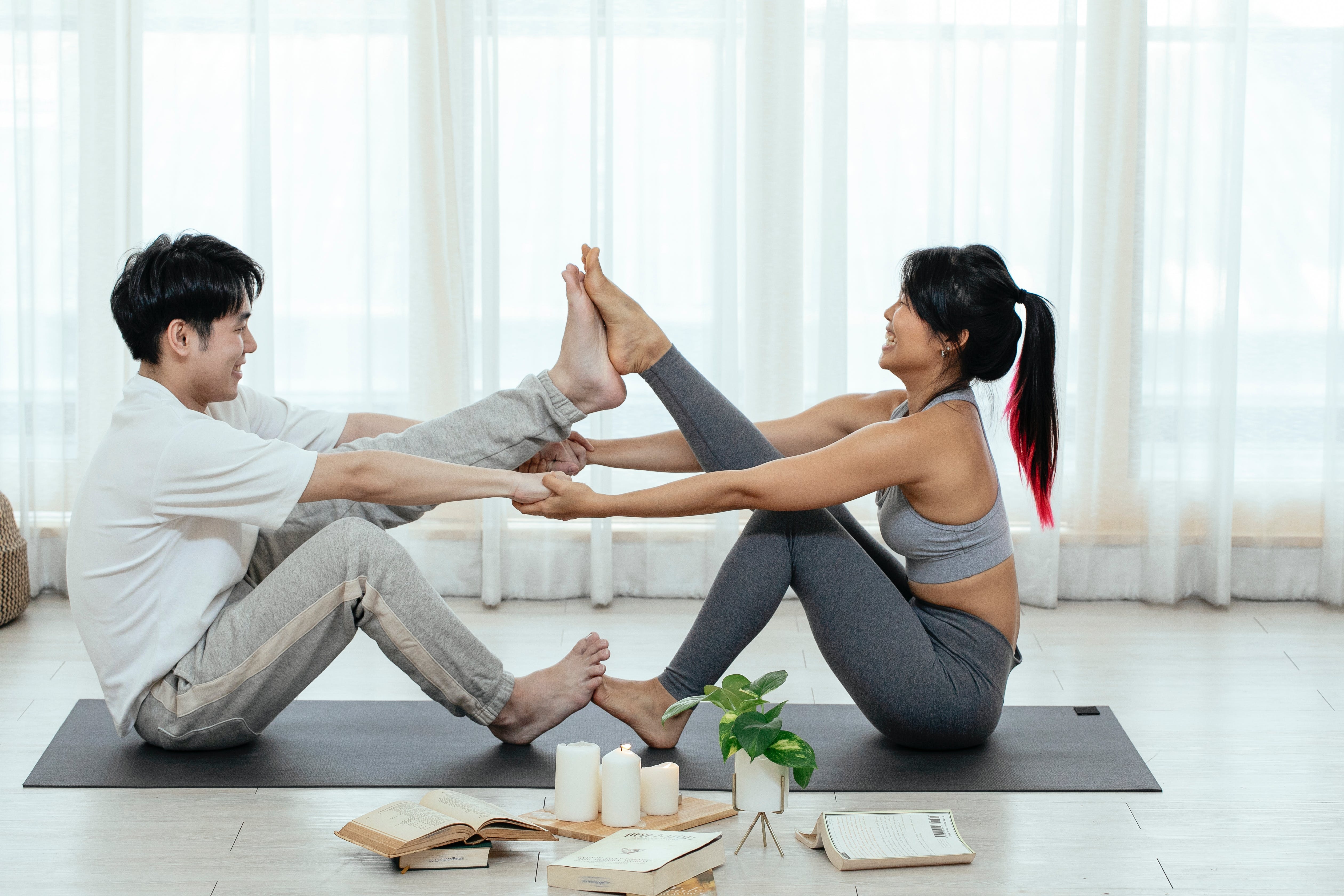 couple stretching on a yoga mat at home