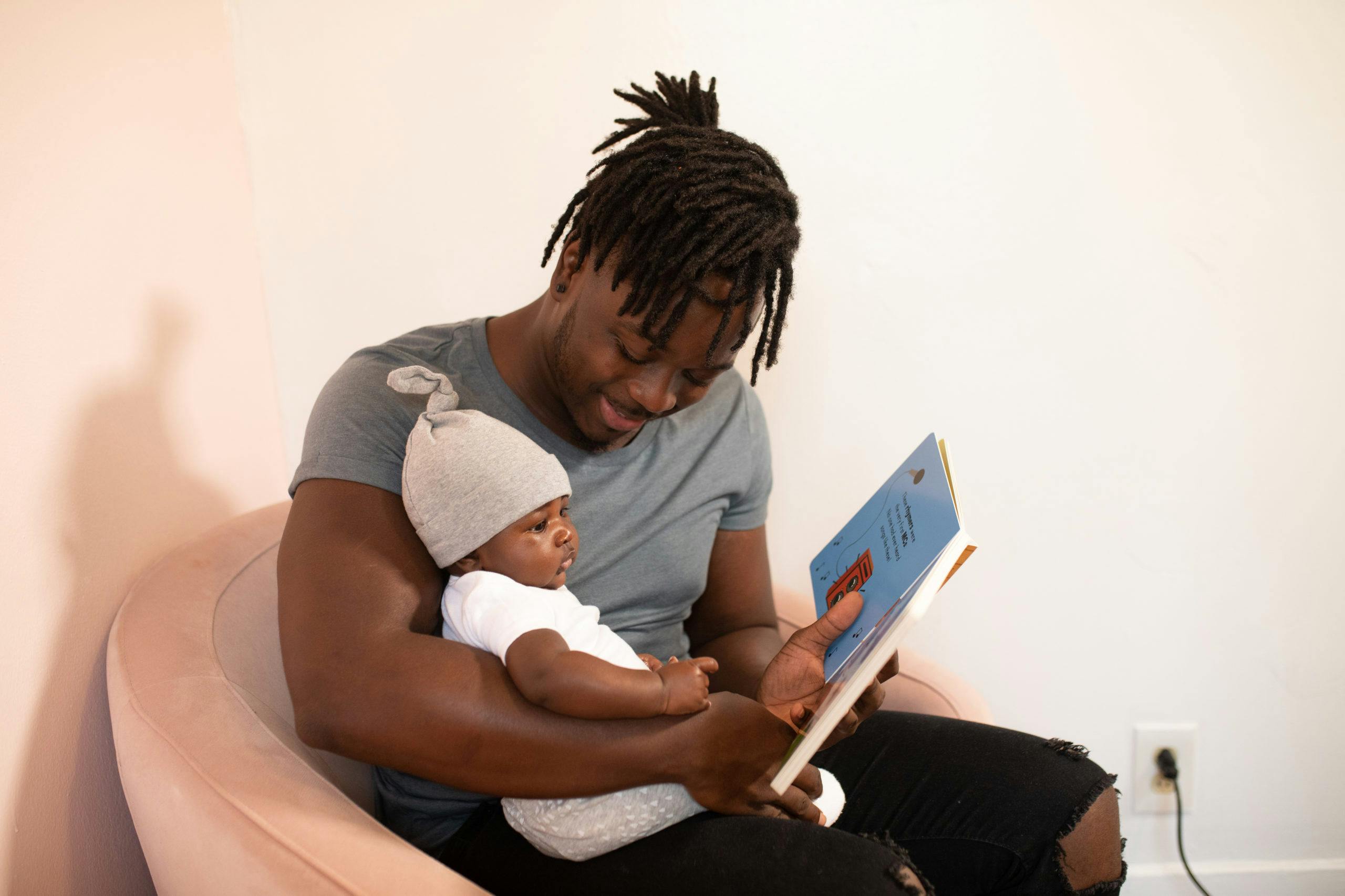father reading a book to his son