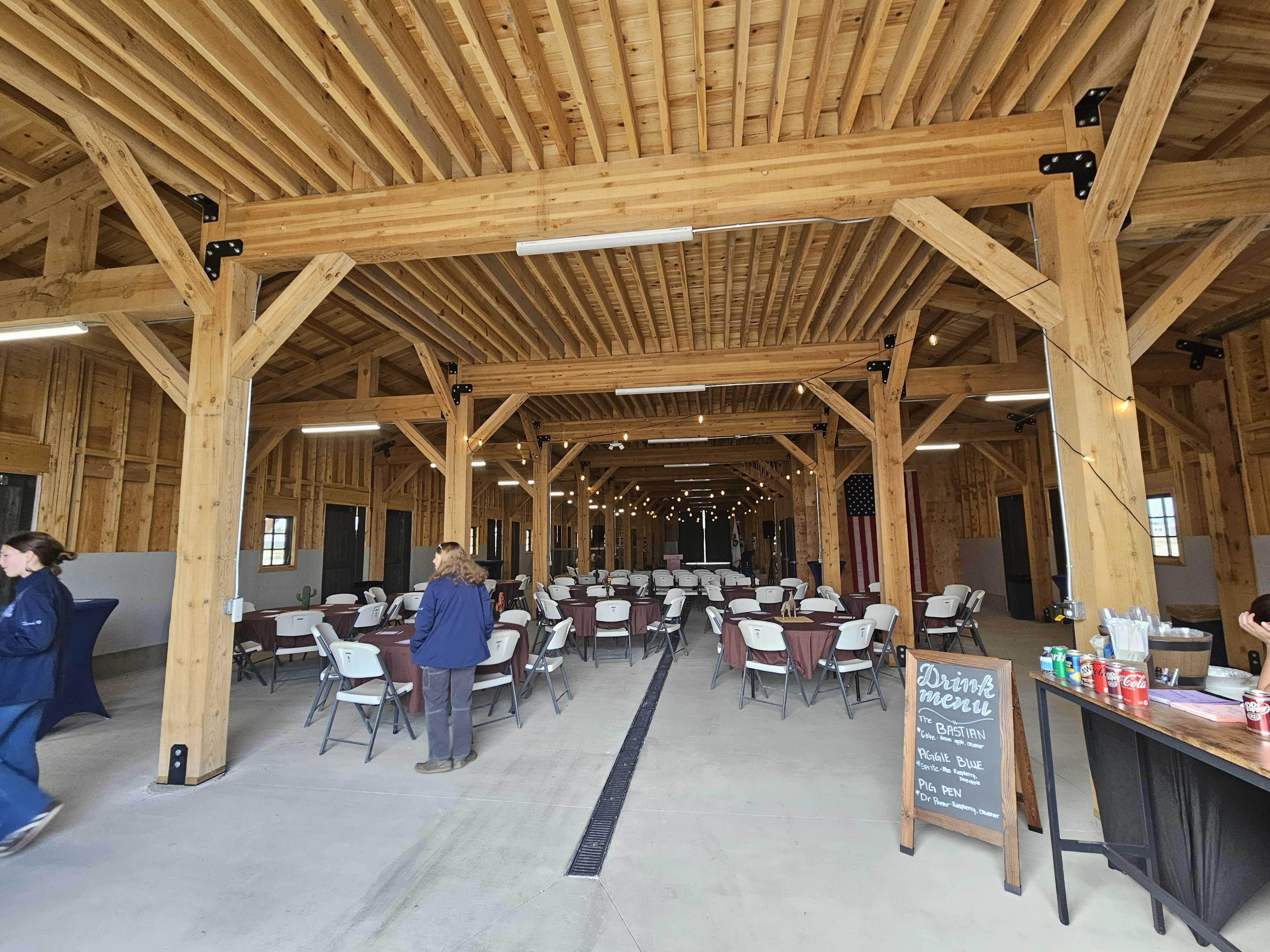 The inside of a barn set up with tables for an event.