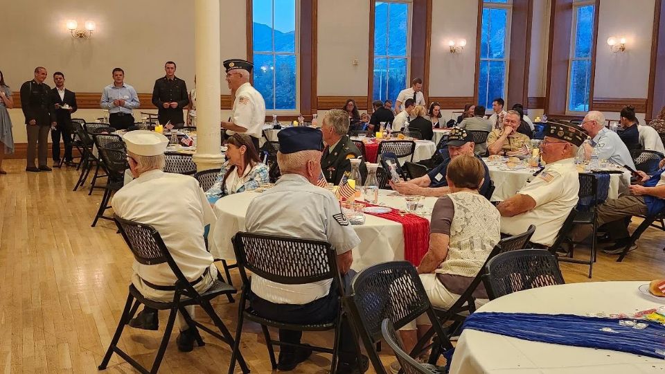 Veterins sitting at tables at an event.