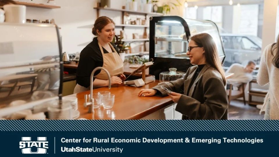 Young worker speaking with a customer at a café, with the Utah State University Center for Rural Economic Development and Emerging Technologies logo and name along the bottom.
