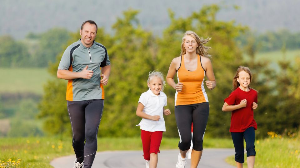 Family of four running on a trail.