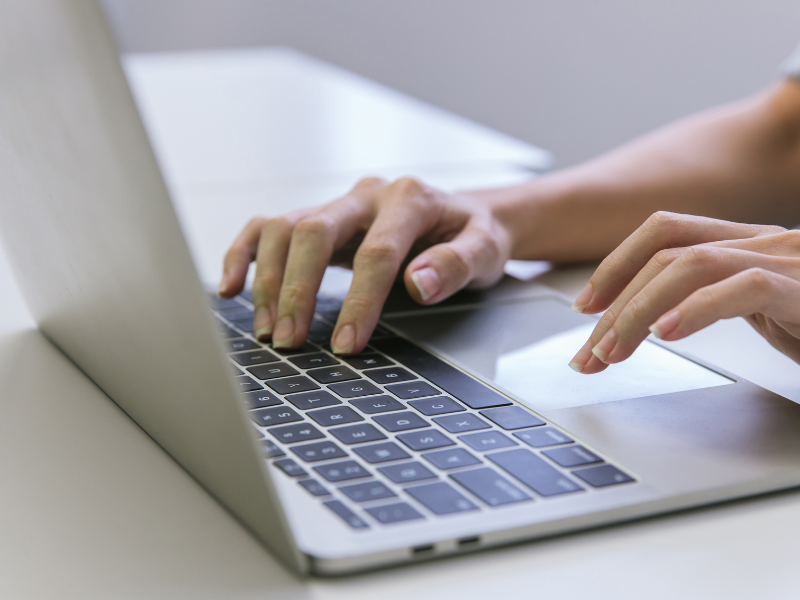 hands typing on a laptop computer