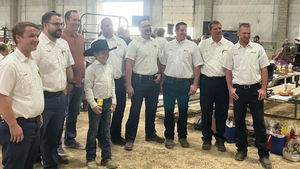 A young boy standing with a group of men.