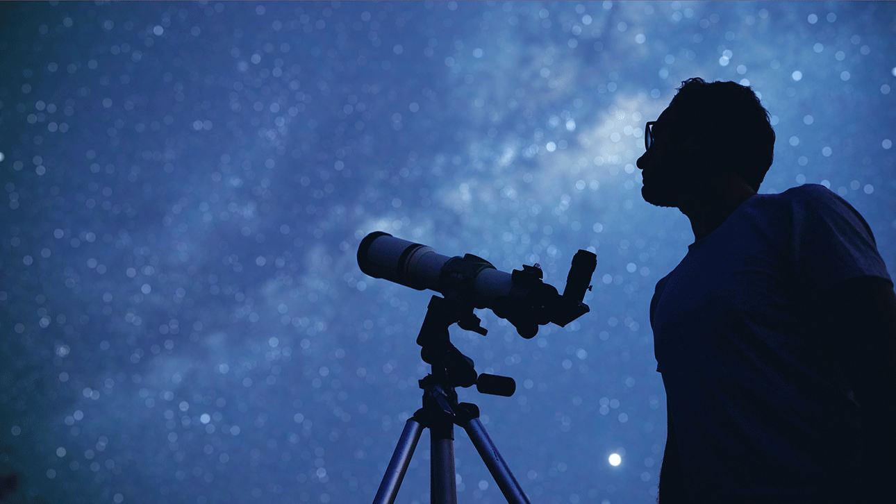 Photo of astronomer looking through a telescope