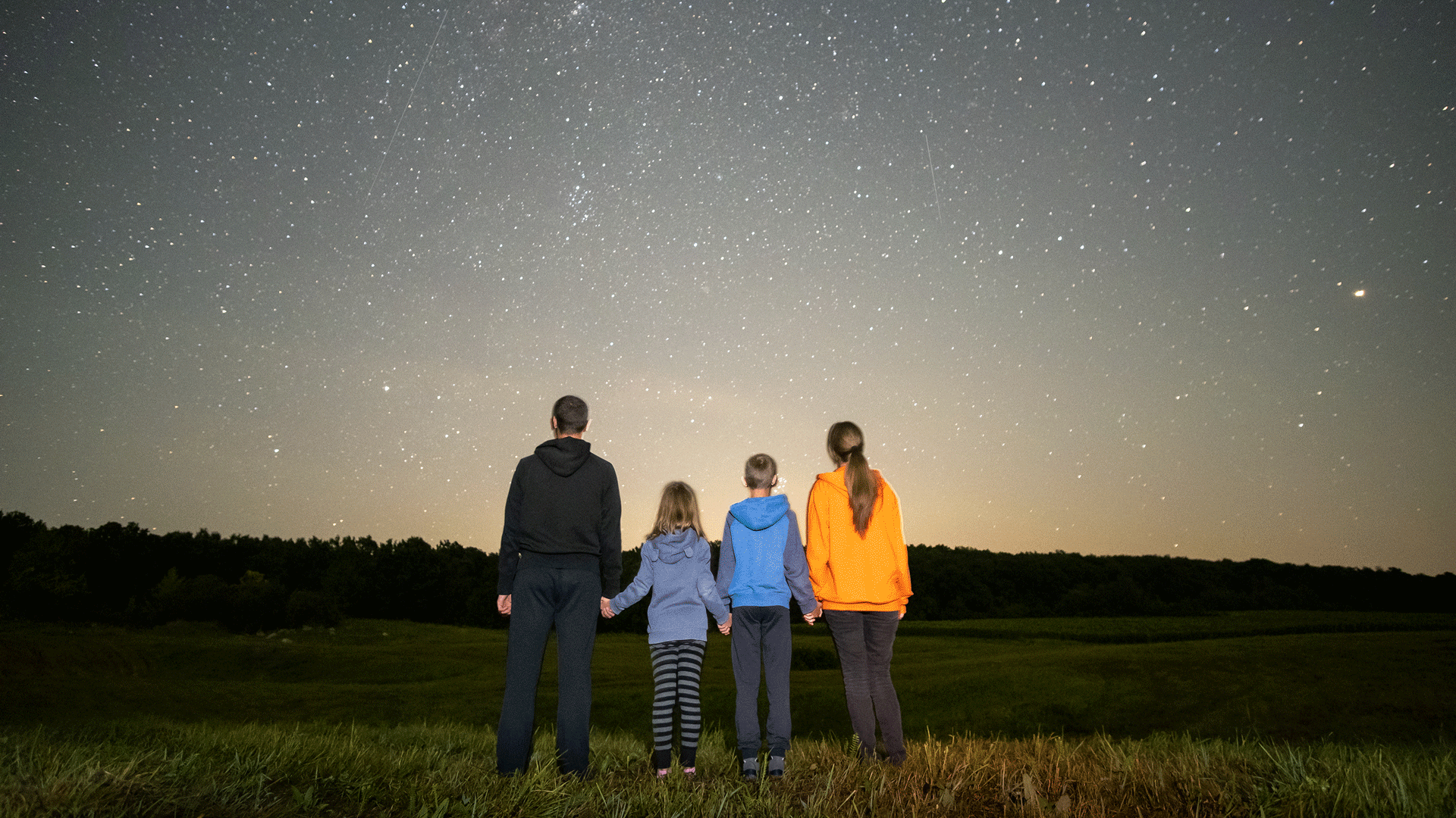 People gathered outdoors under a star-filled sky