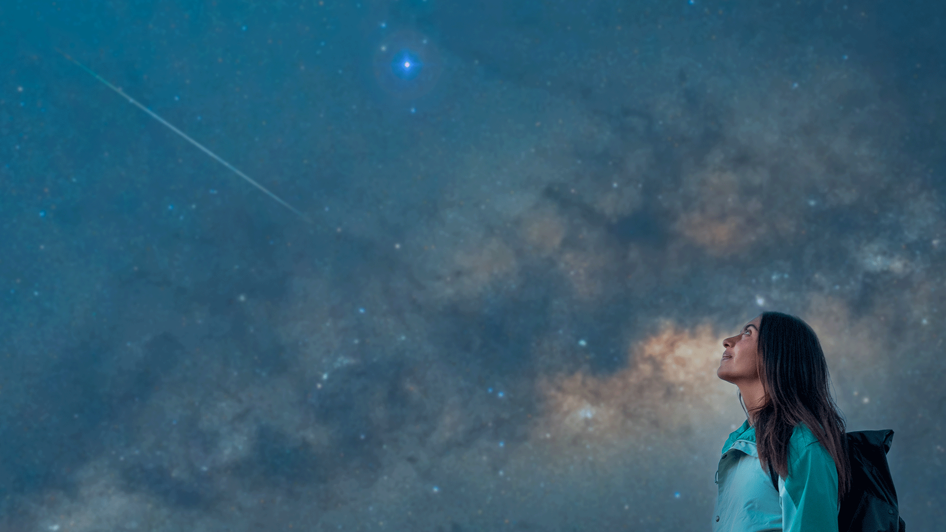 Woman looking up at a dark night sky