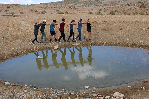Utah youth in a line next to a small pond