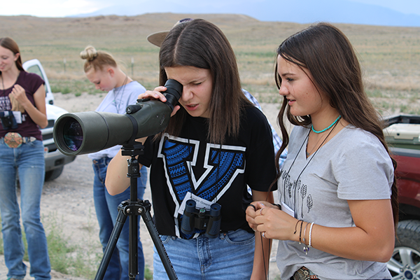 Two students looking through a scope