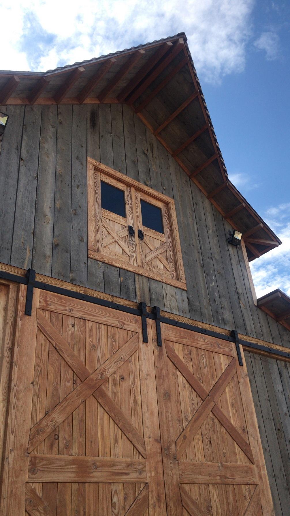 Building with sliding, barn-style doors constructed from mass timber
