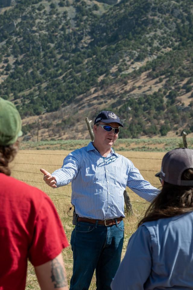 Man talking to a group of people in a field