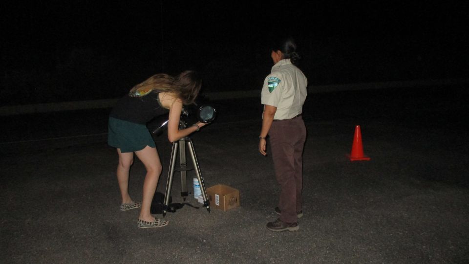 A Bureau of Land Management park ranger shows a visitor the night sky through a telescope. BLM Photo.

