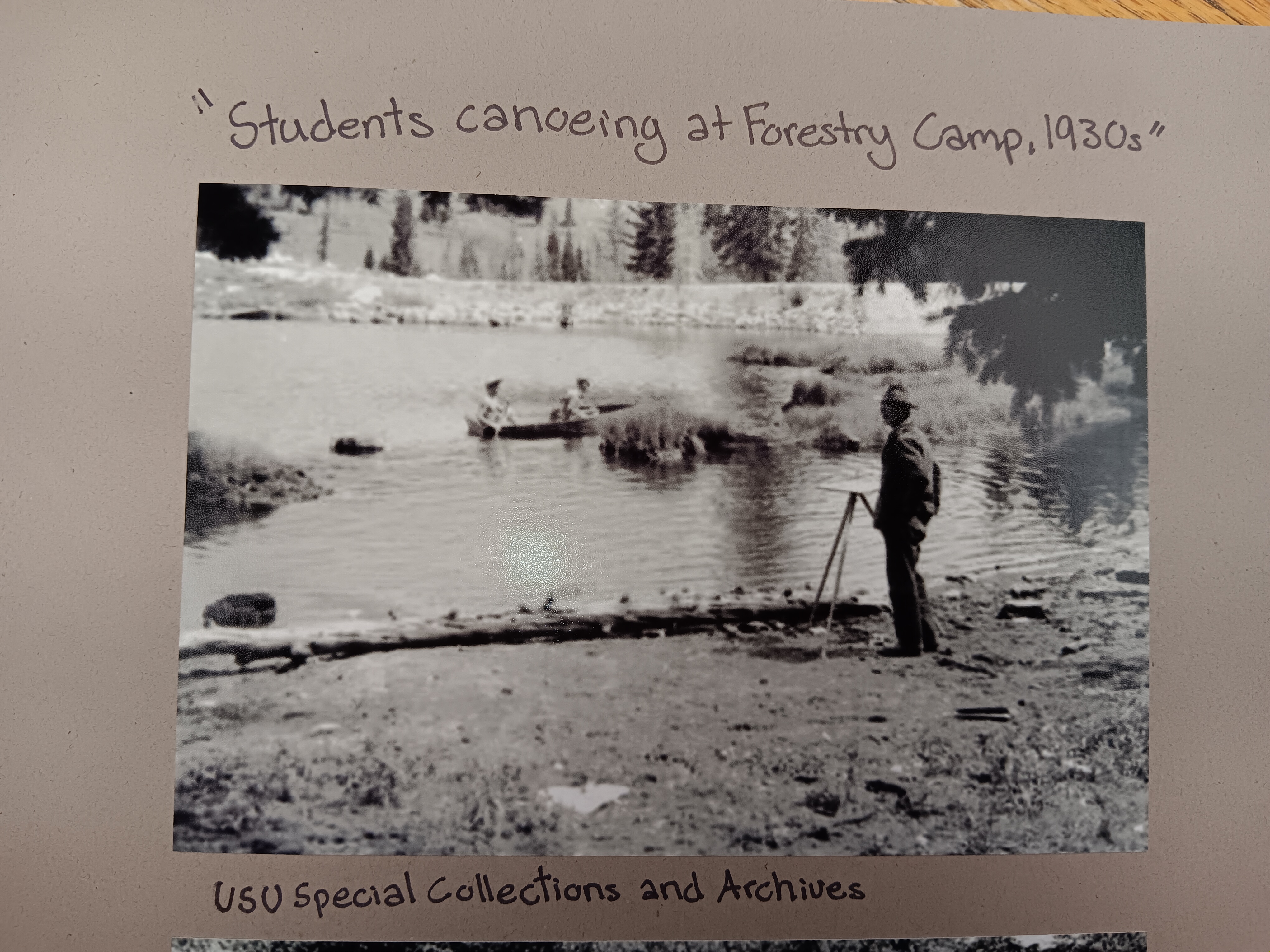 Black and white photo of students canoeing on a lake.