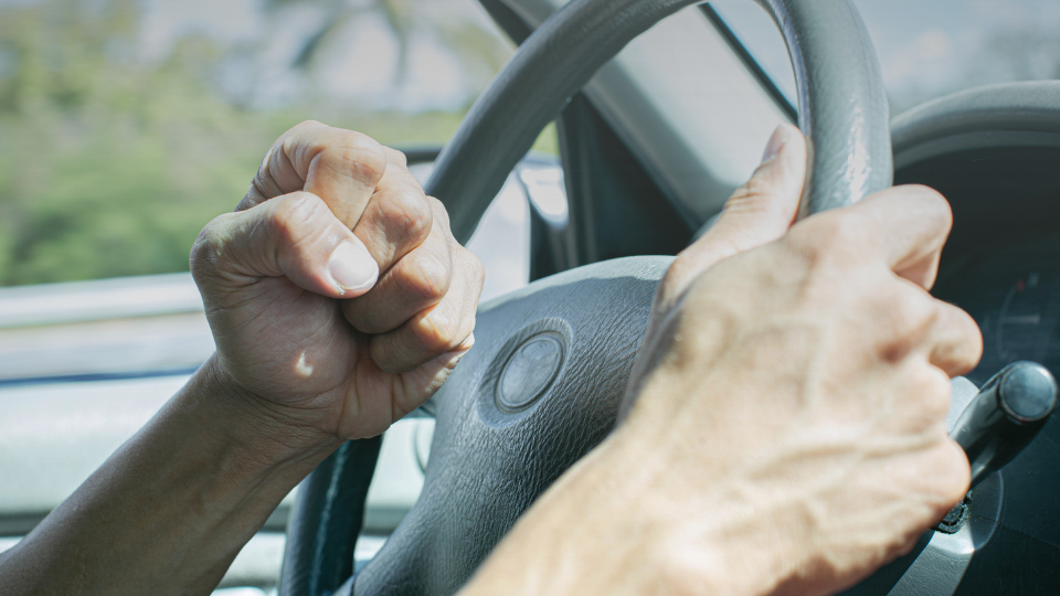 person driving with their hand in a fist