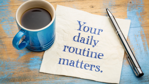 coffee and a napkin that says, 'your daily routine matters'. 