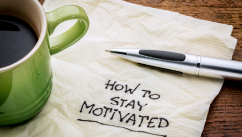 coffee and a napkin that says 'how to stay motivated'