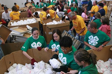 People in 4-H shirts helping to package meat.