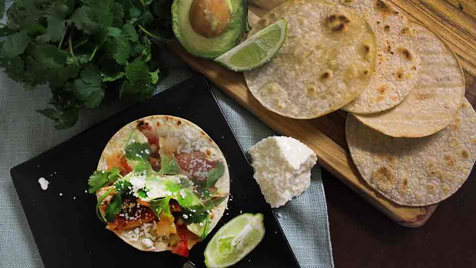Mahi Mahi taco with ingredients (cilantro, fish, cheese, avacado)