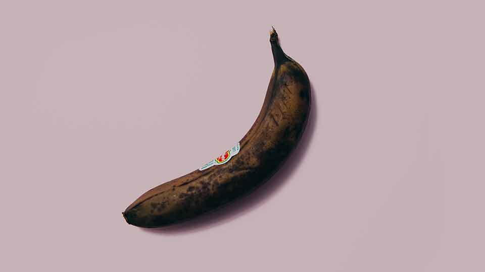 Brown banana on pink background
