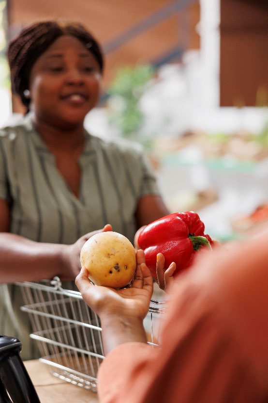 Woman handing produce to shopper