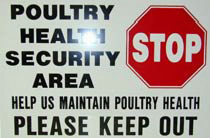 Sign reading 'Poultry Health Security Area, help us maintain poultry health, please keep out' next to a red stop sign.