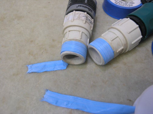 Blue sealing tape on pipe threads.