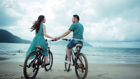Couple holding hands on bikes
