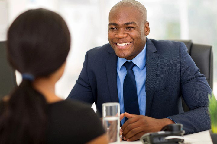 A man talking to a women across a desk.