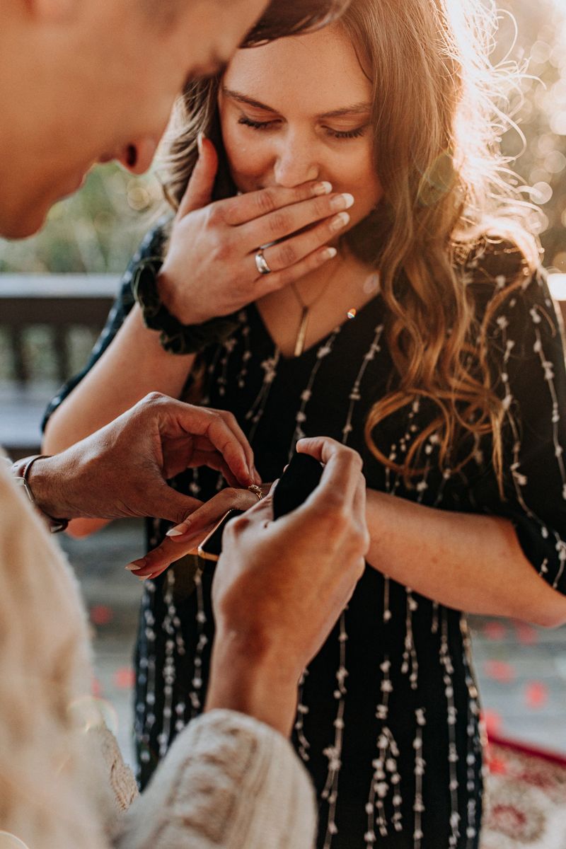couple putting on ring after being engaged