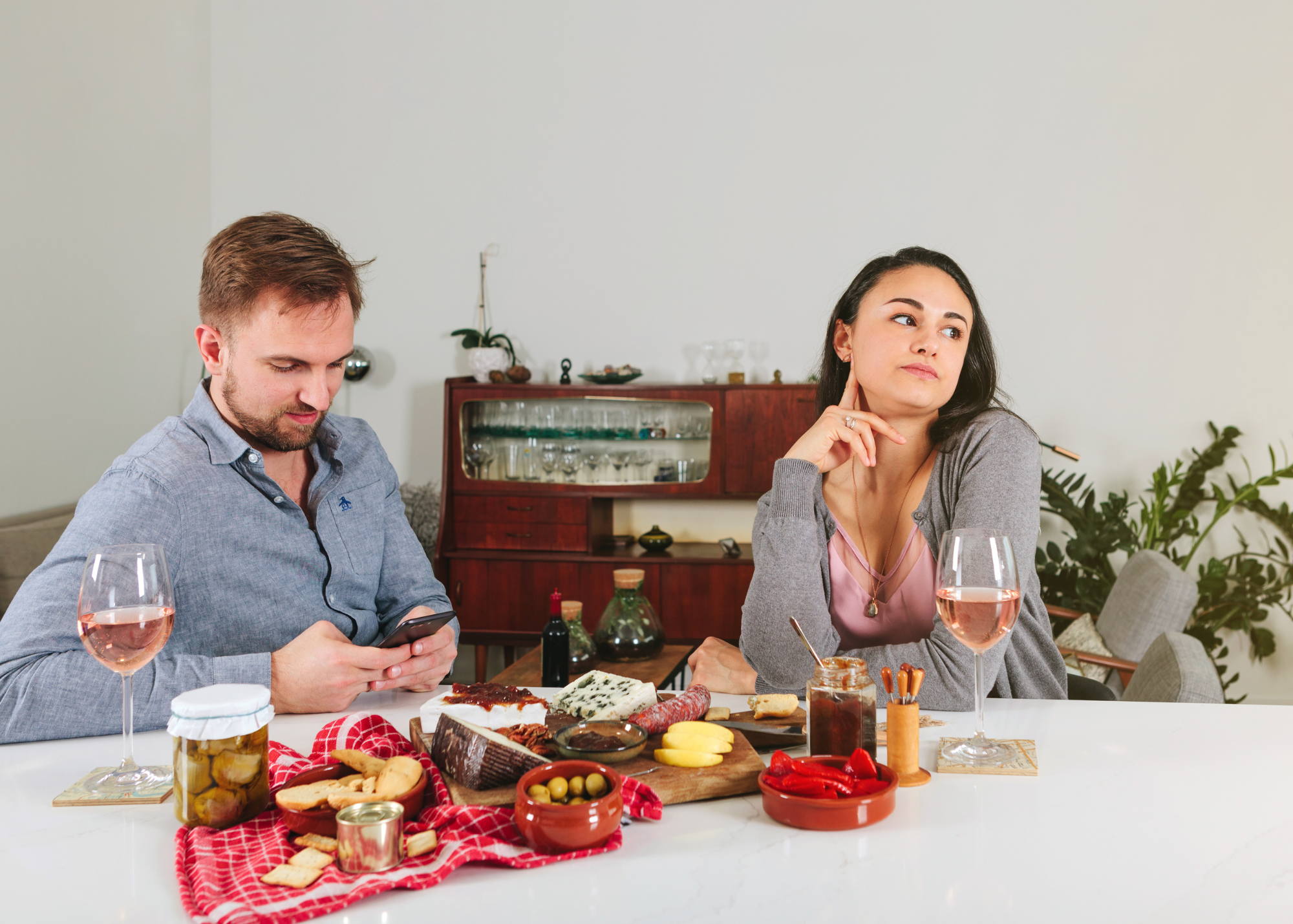 man and woman sitting at table looking disappointed with each other